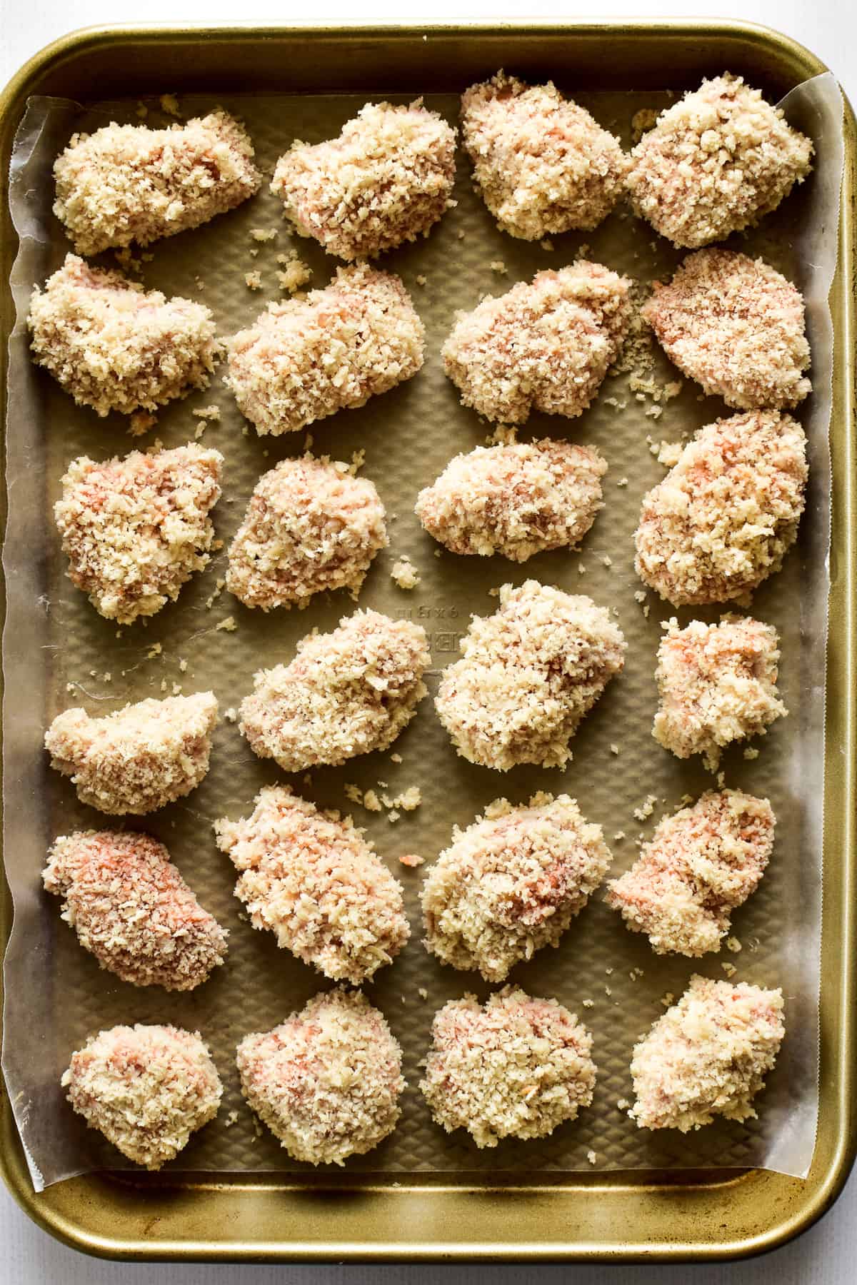 Panko-coated chicken nuggets on a baking sheet