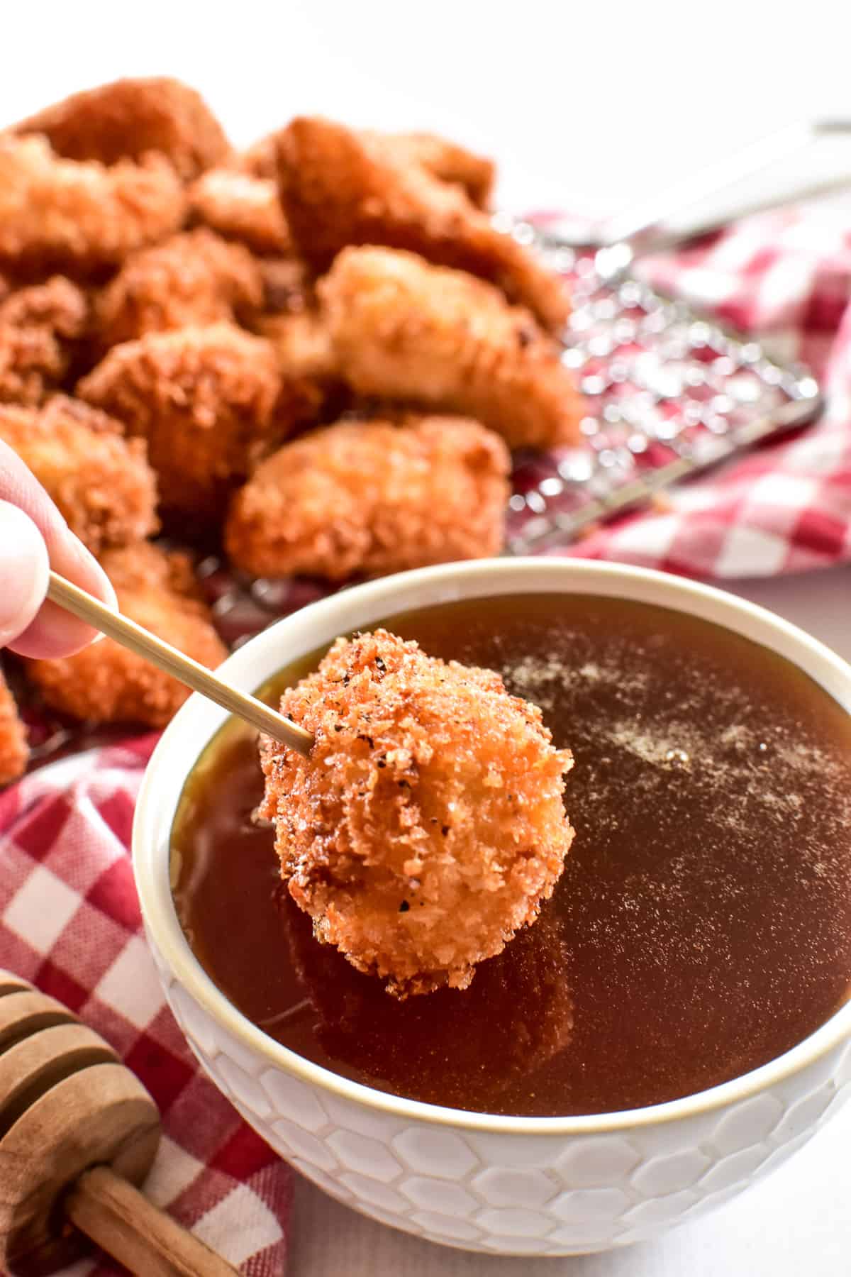 Crispy Chicken Nugget being dipped into Hot Honey