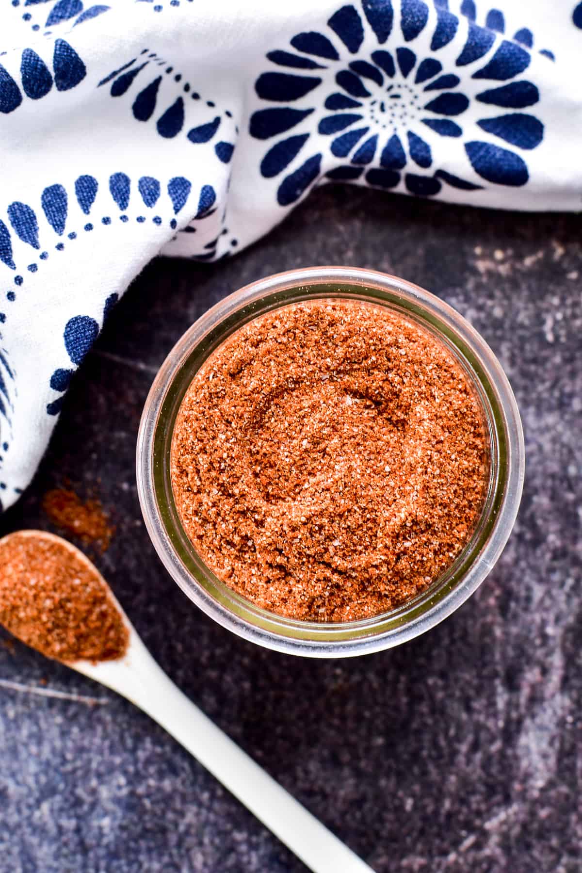 Overhead image of Fajita Seasoning in a glass jar with a small spoon