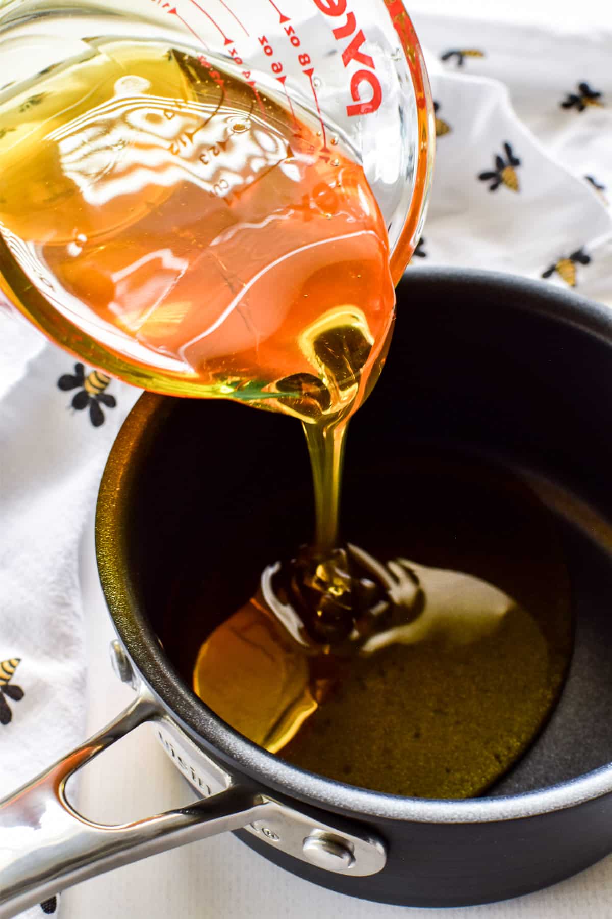 Honey pouring into a saucepan