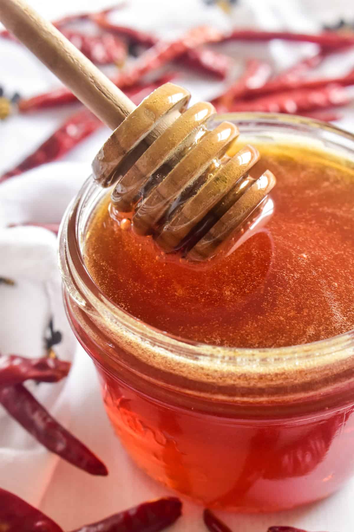 Honey dipper in a jar of hot honey