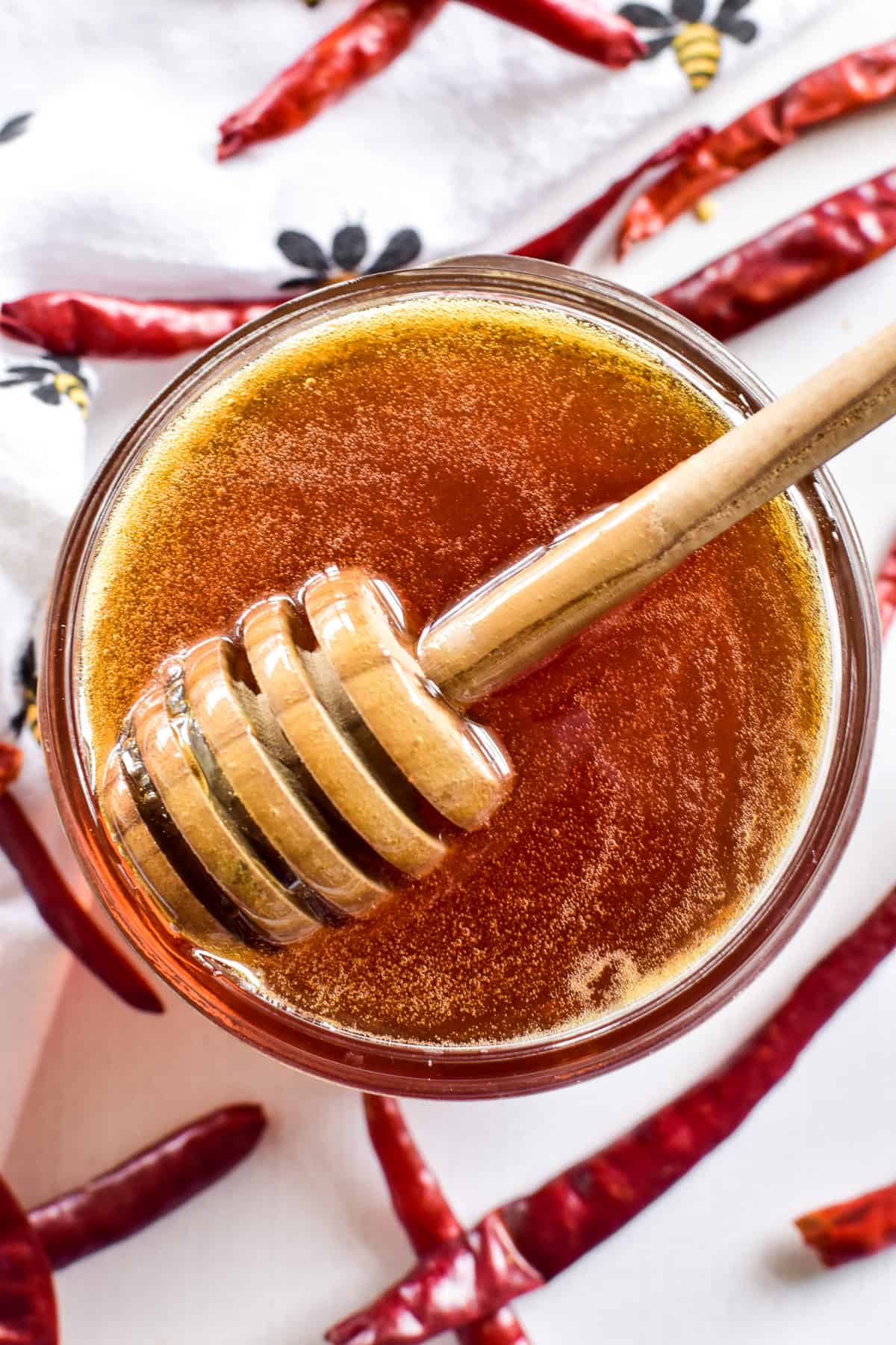 Overhead image of hot honey in a jar with a honey dipper