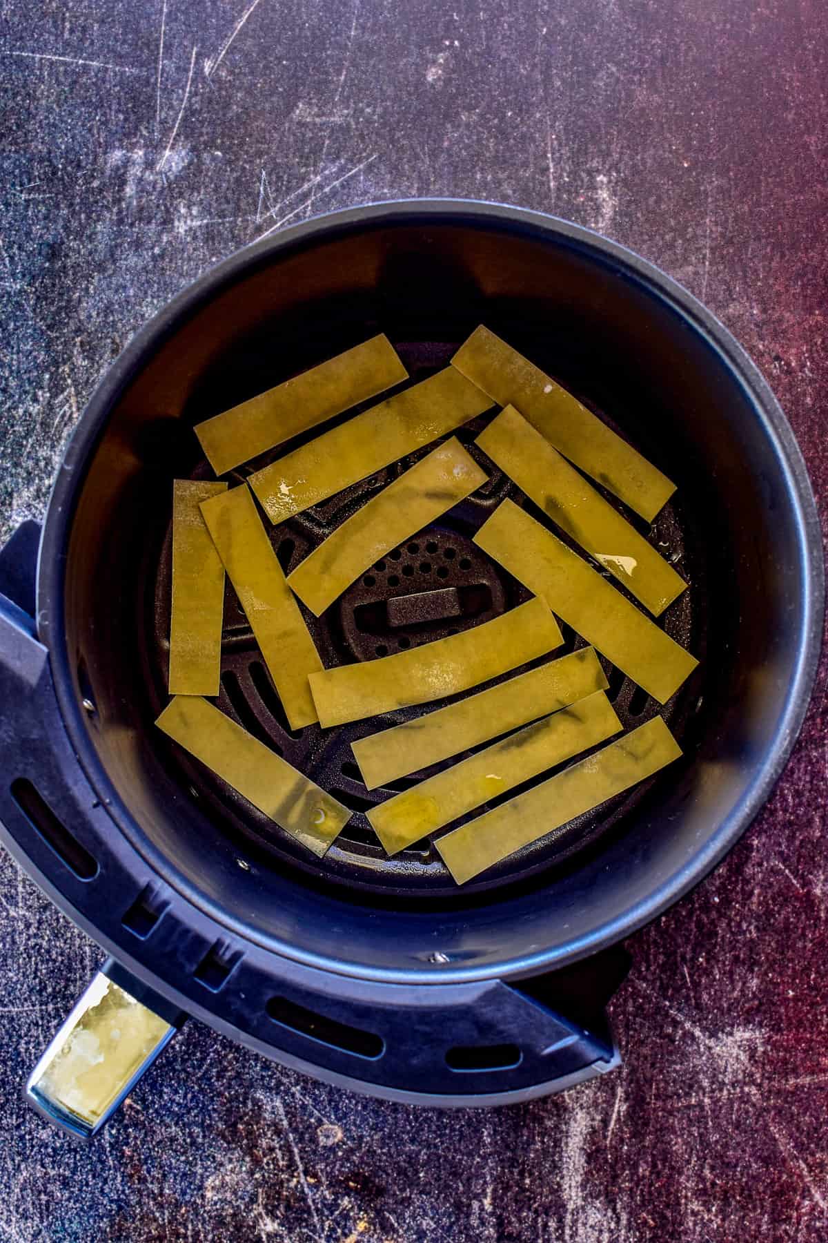 Wonton strips in an air fryer basket