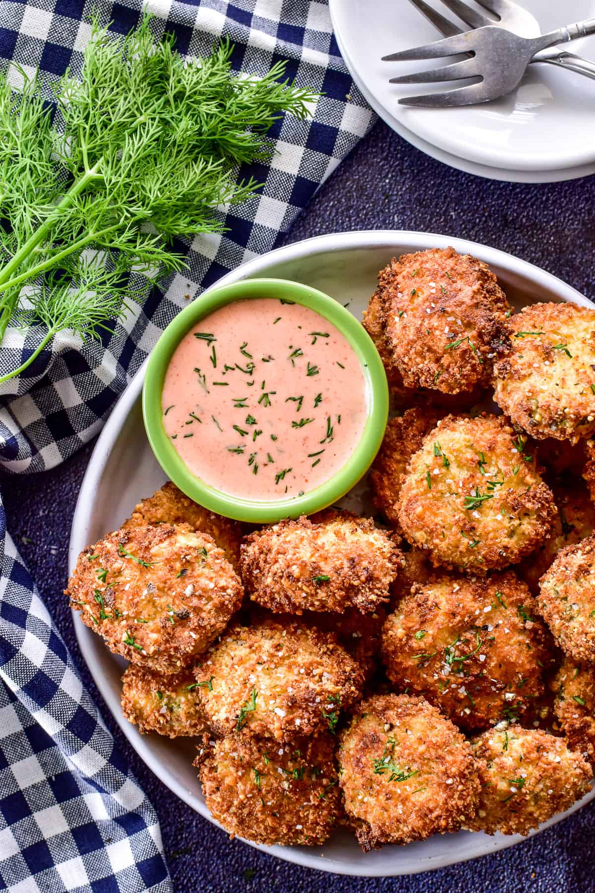 Air Fryer Pickles on a plate with fresh dill and sriracha ranch sauce