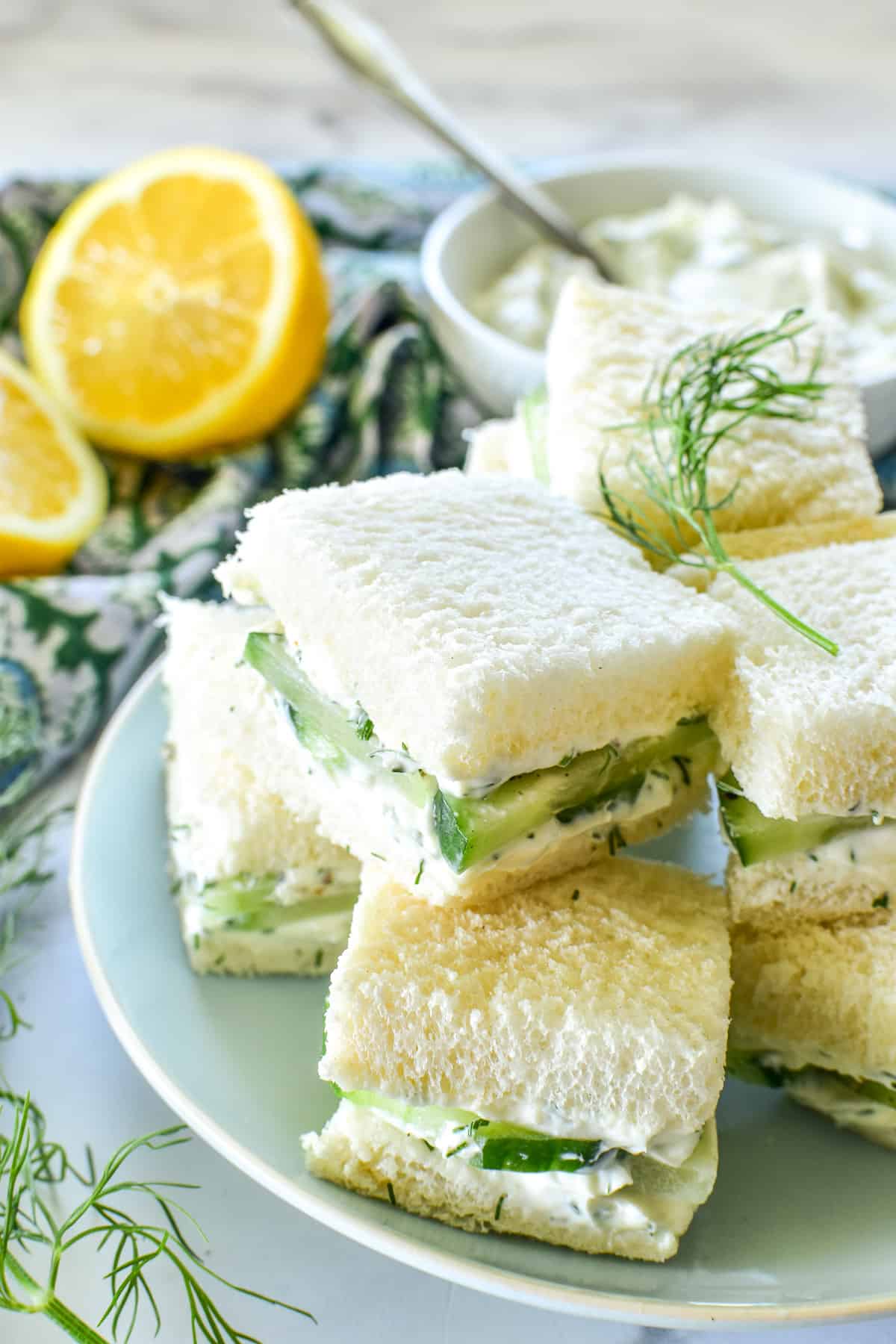 Cucumber Sandwiches cut in squares on a light blue plate