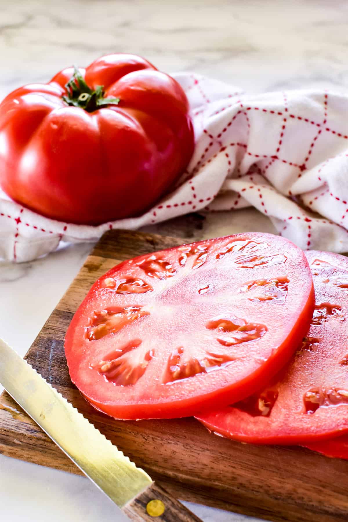 Tomatoes sliced on a wooden cutting board