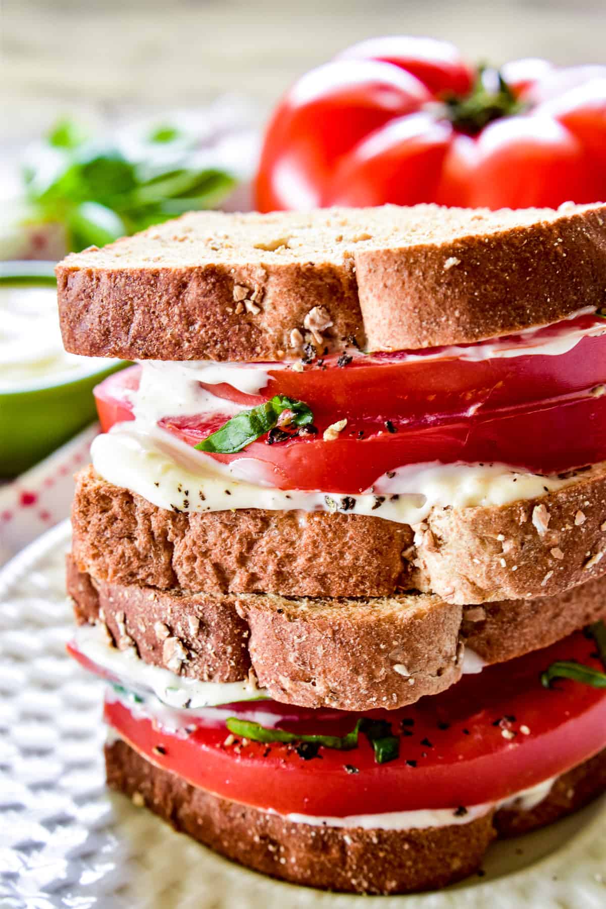 Double decker tomato sandwich on a white plate