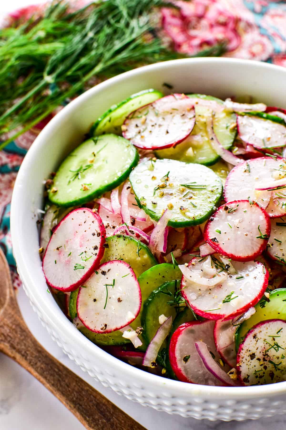 Side shot of Radish Salad in a serving bowl with fresh dill