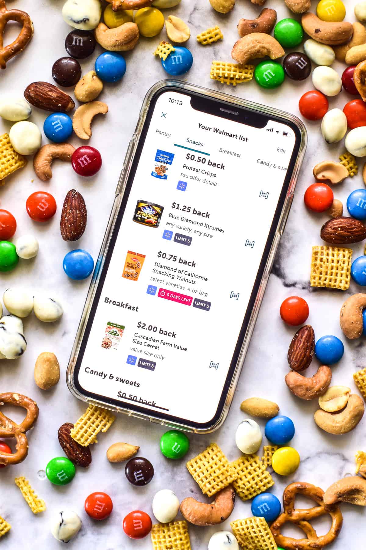 Phone showing Ibotta app surrounded by trail mix