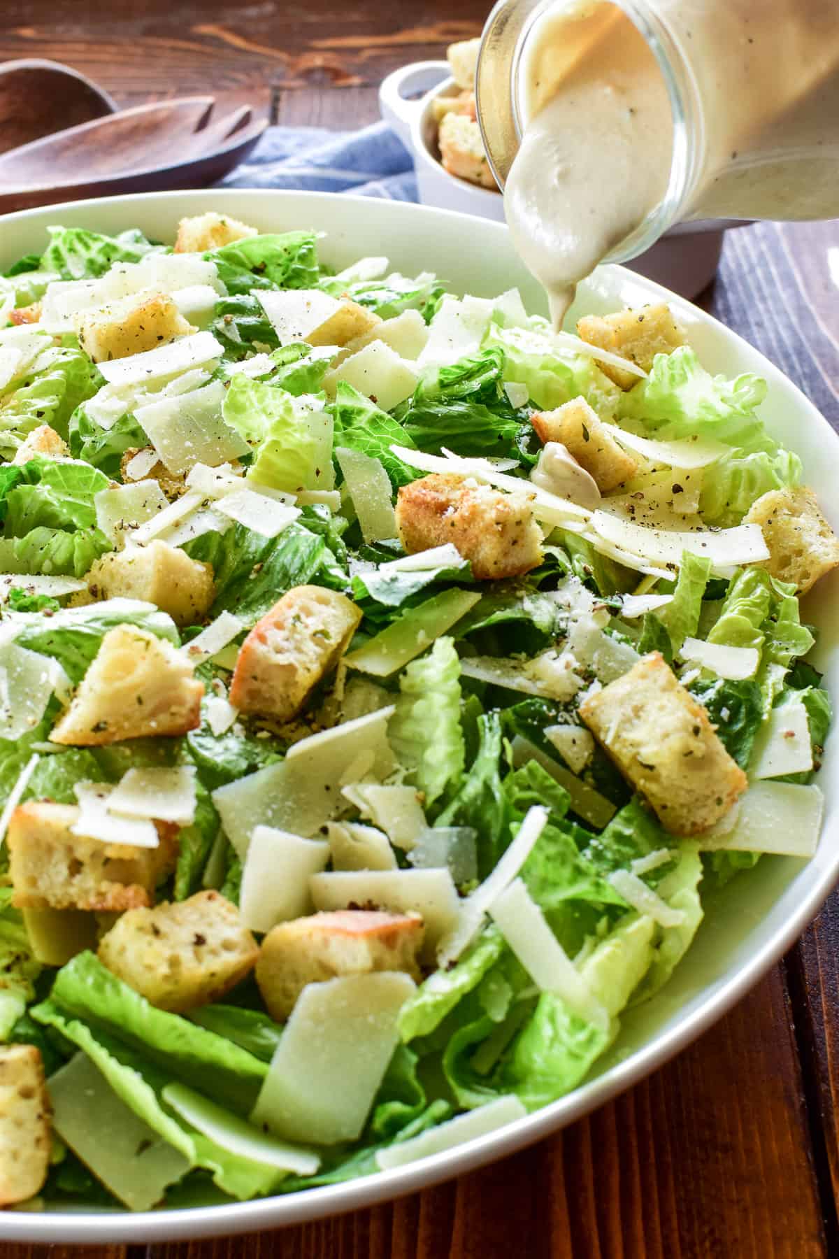 Caesar Dressing being poured onto a salad