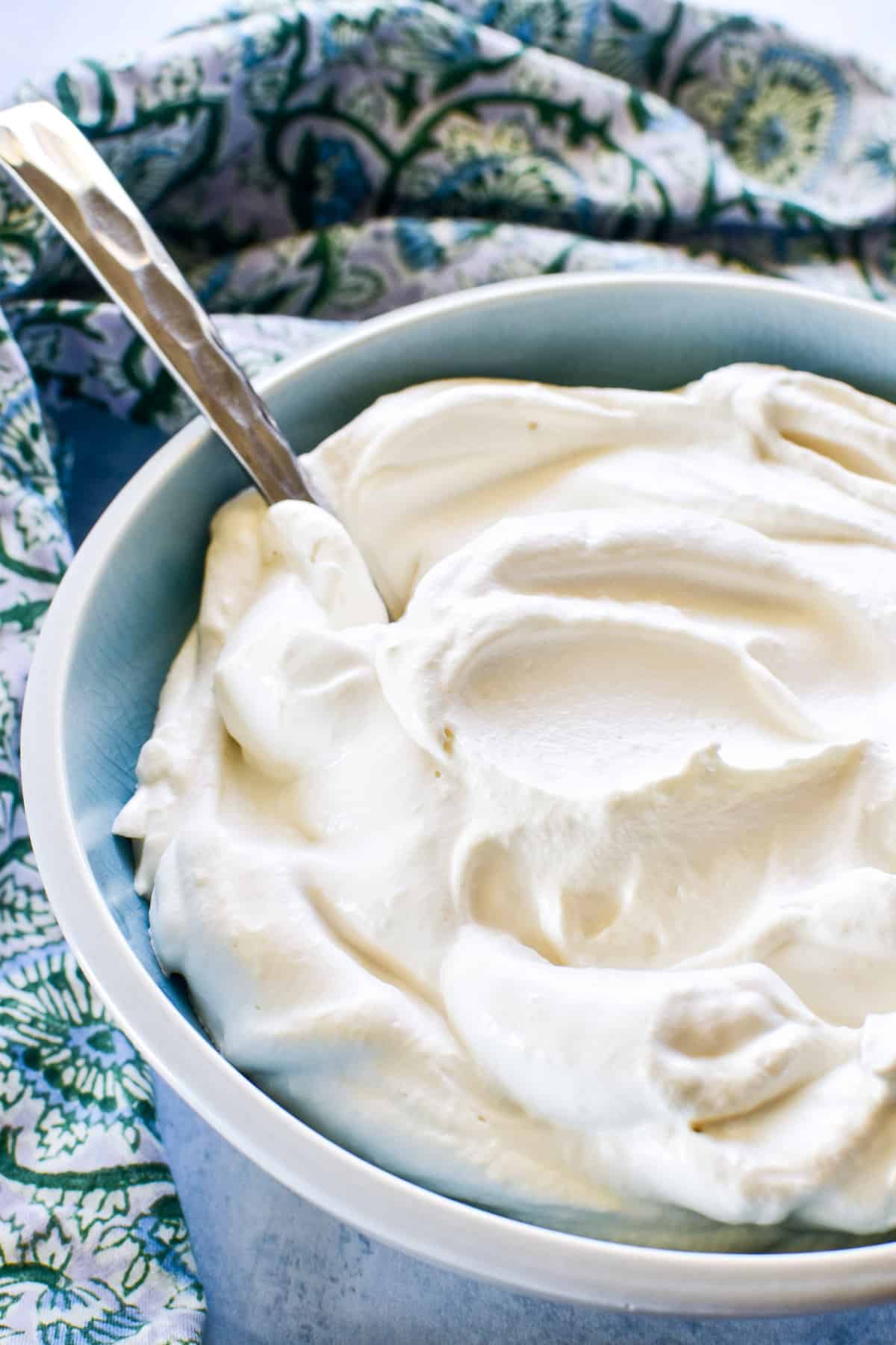 Homemade Cool Whip in a blue bowl with a spoon