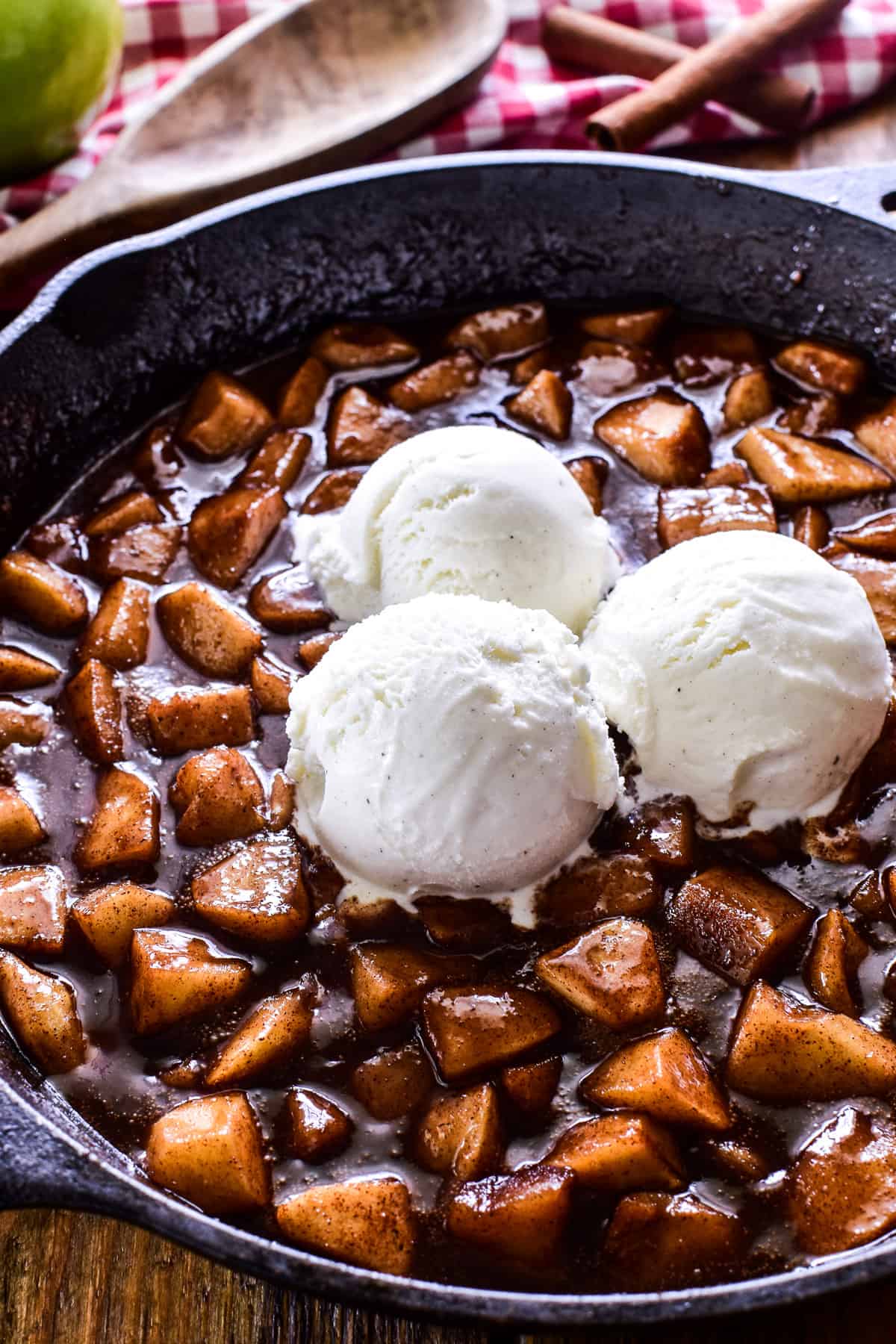 Close up of Fried Apples in a cast iron skillet with vanilla ice cream