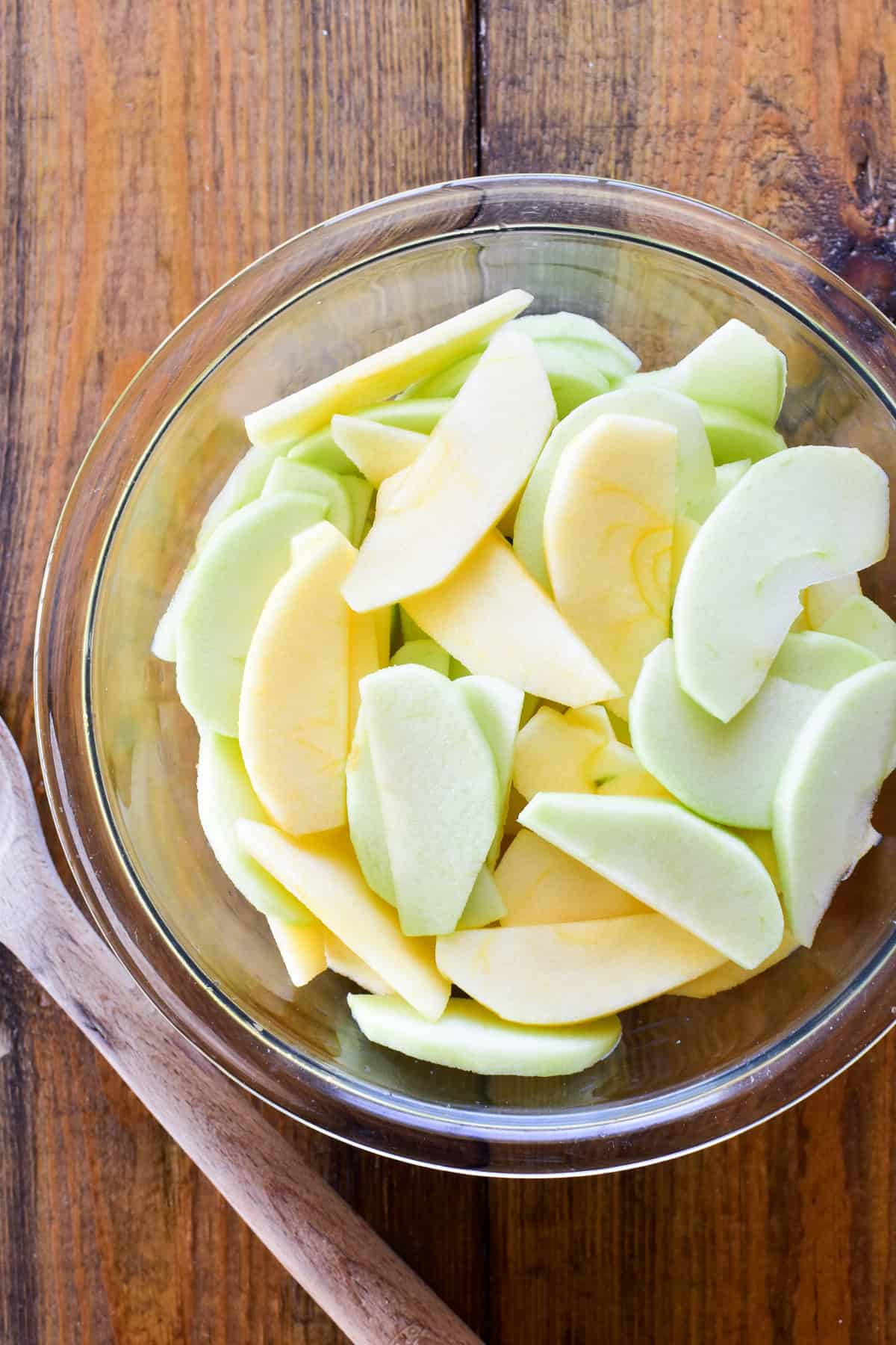 Sliced apples in a glass mixing bowl