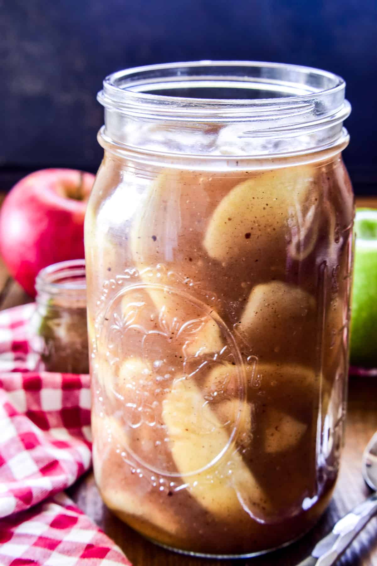 Apple Pie Filling in a glass jar with a red checkered towel