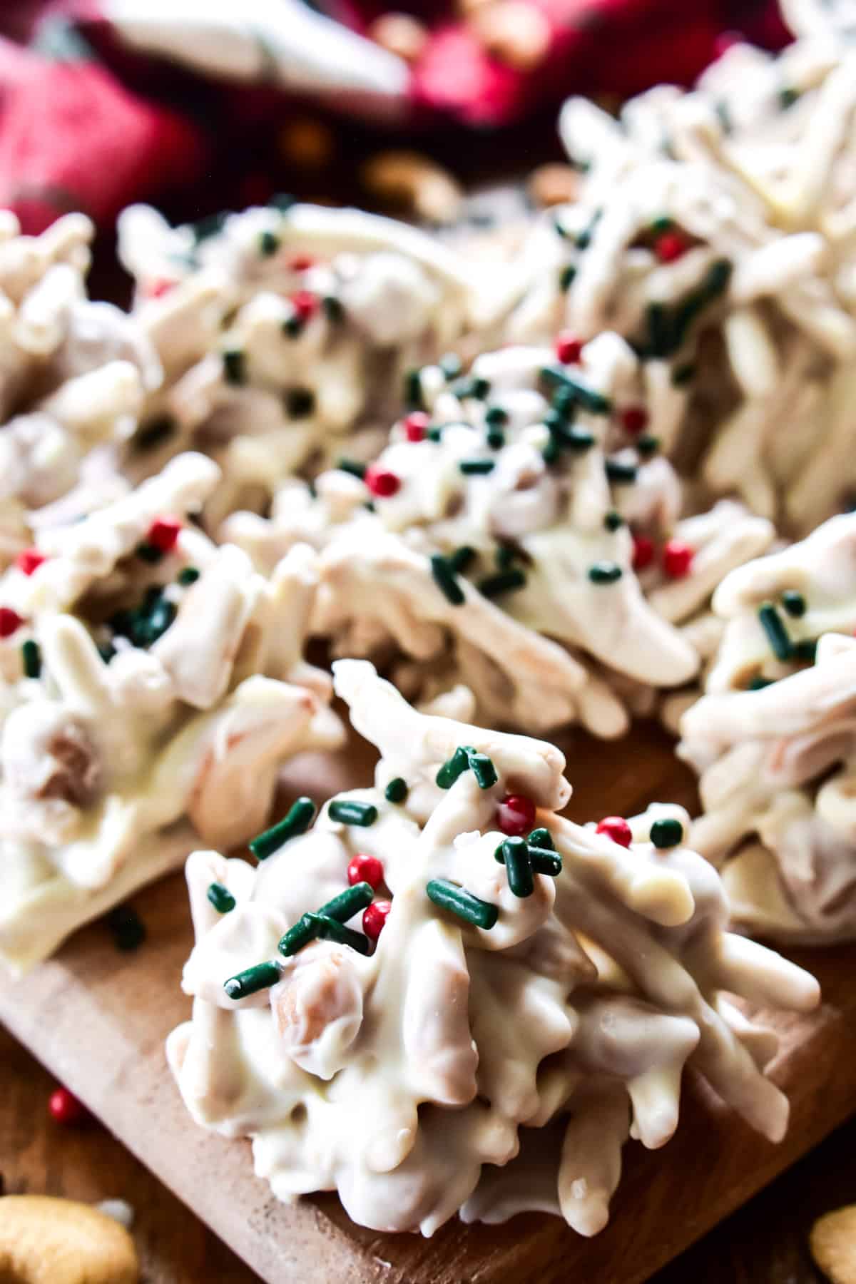 Caramel Cashew Haystacks with red and green sprinkles on a wooden board