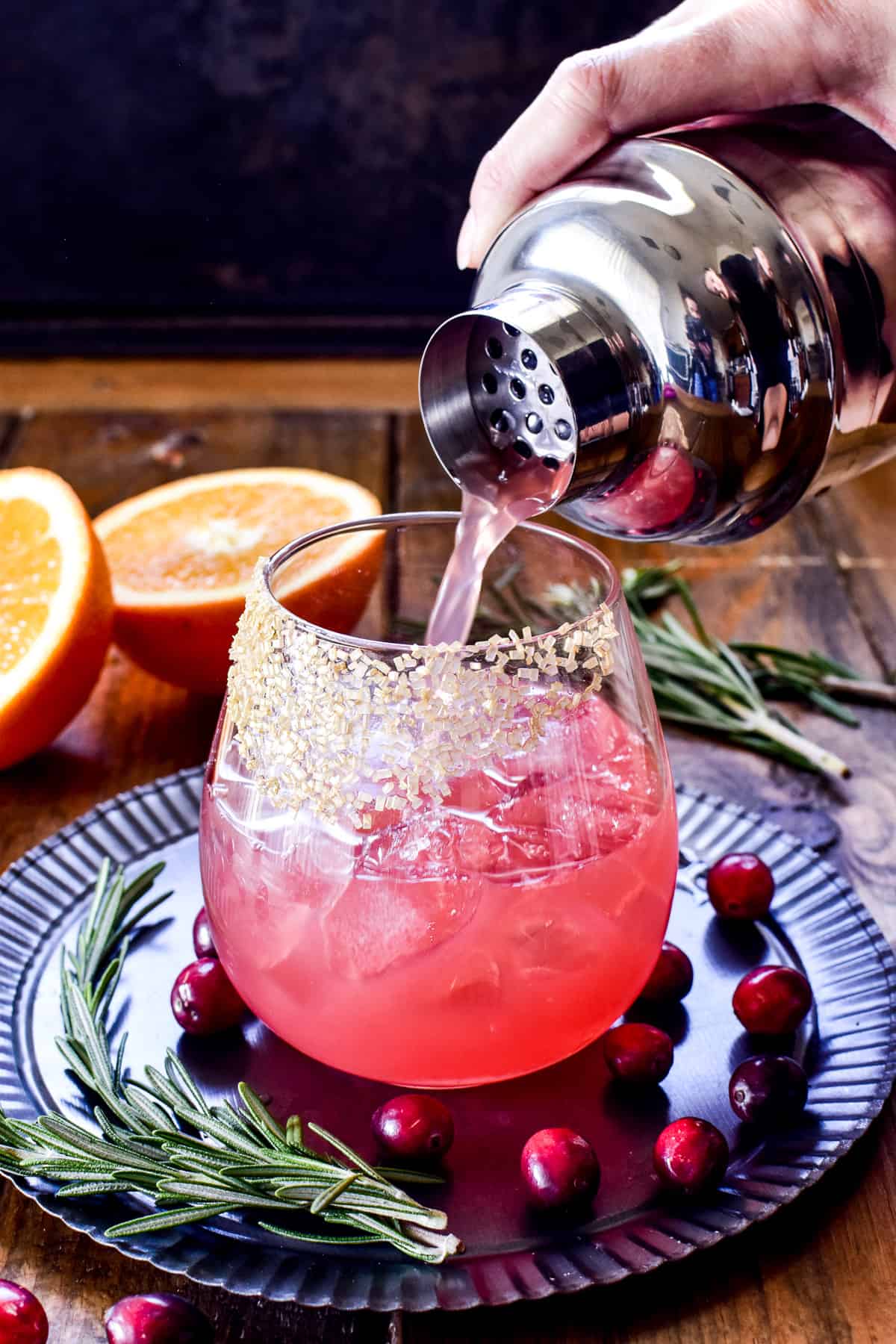 Pouring drink from cocktail shaker into glass