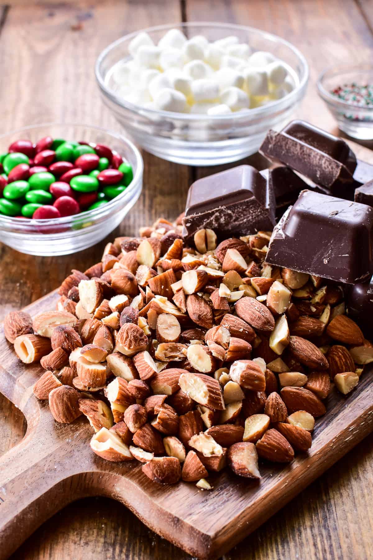 Chopped almonds and chocolate on a wooden cutting board