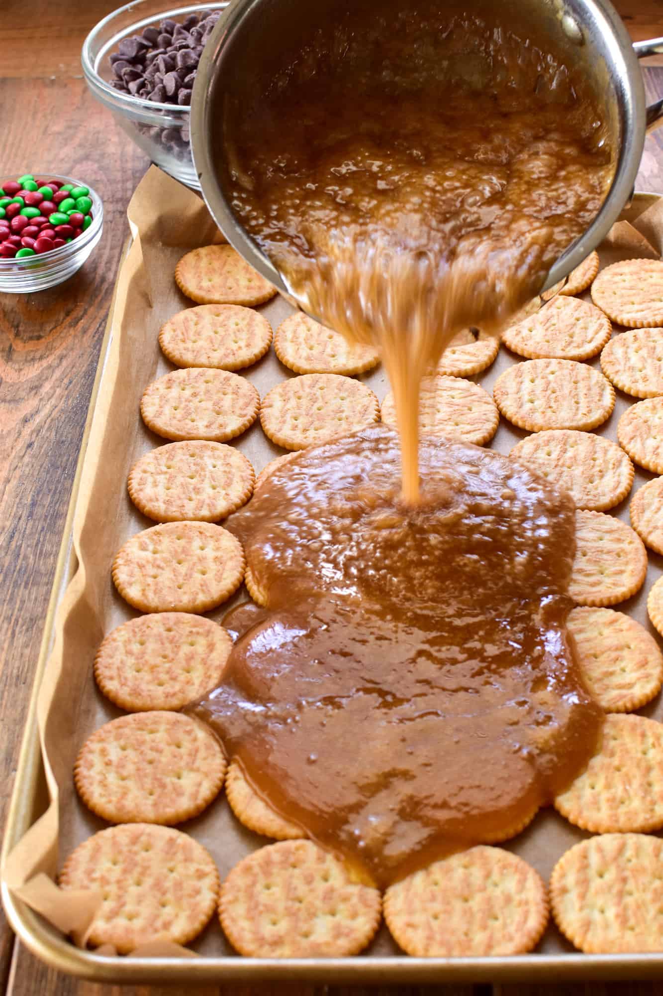 Toffee pouring over crackers for Christmas Crack