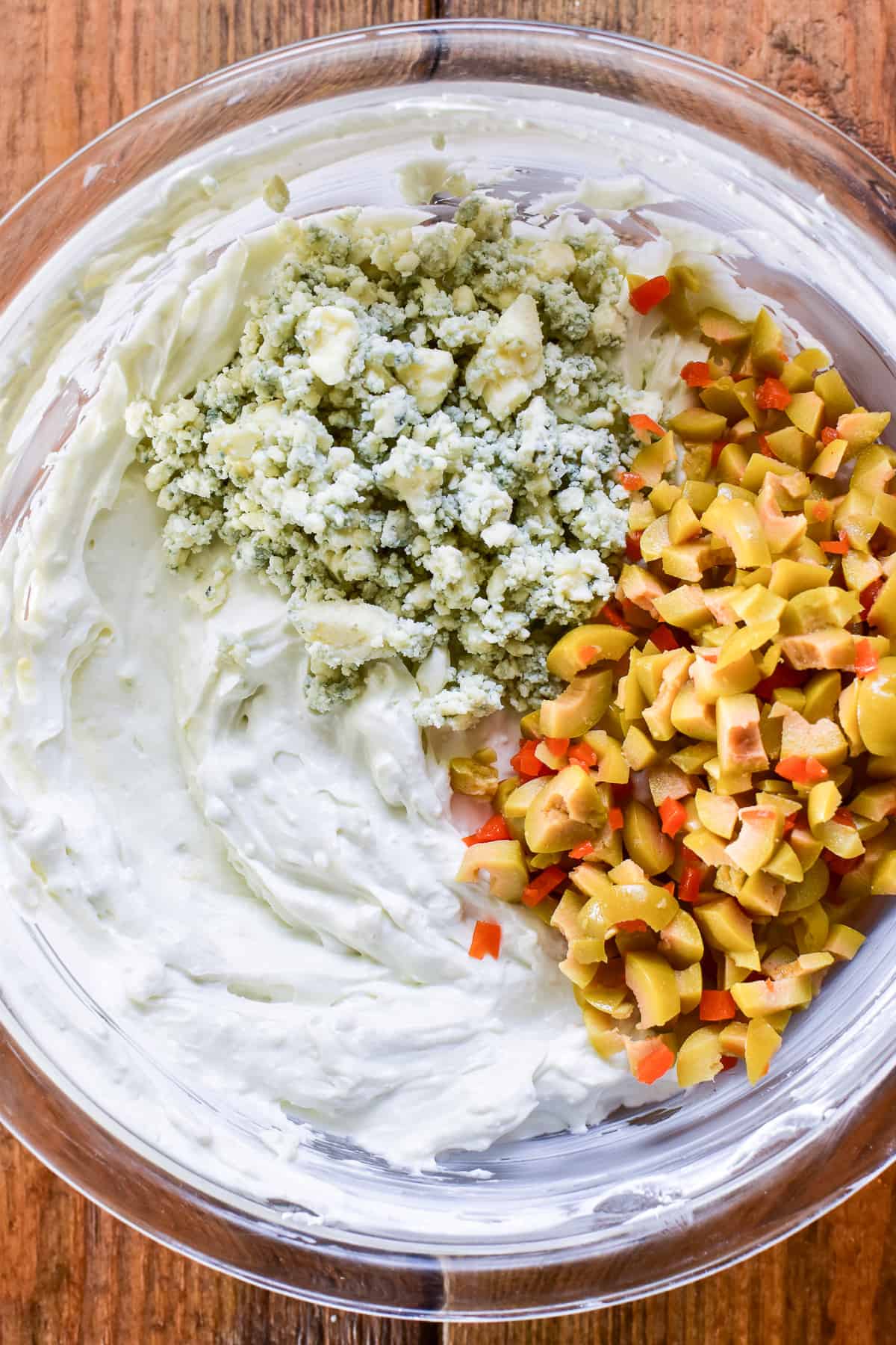 Ingredients for Dirty Martini Dip being combined in a mixing bowl