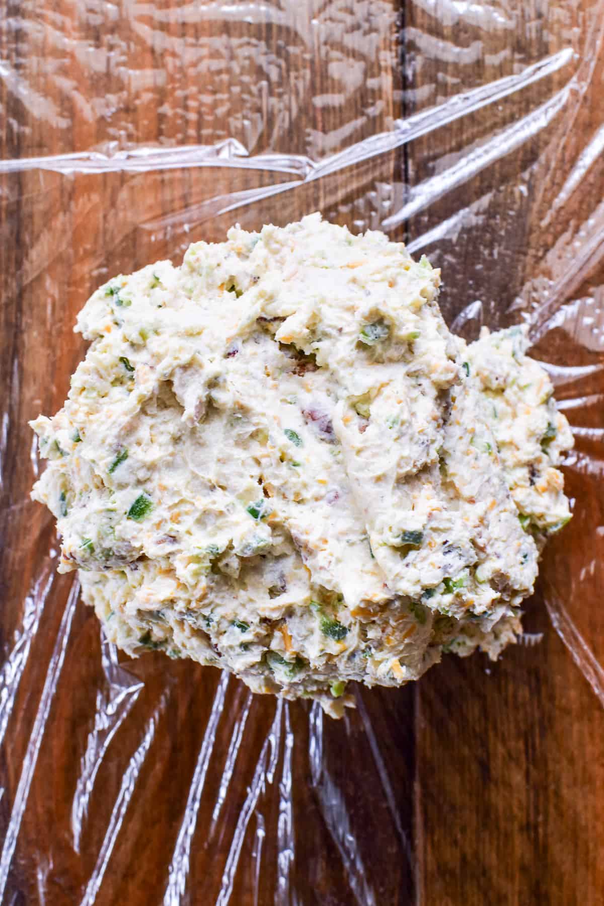 Jalapeño Popper Cheese Ball being wrapped in plastic wrap
