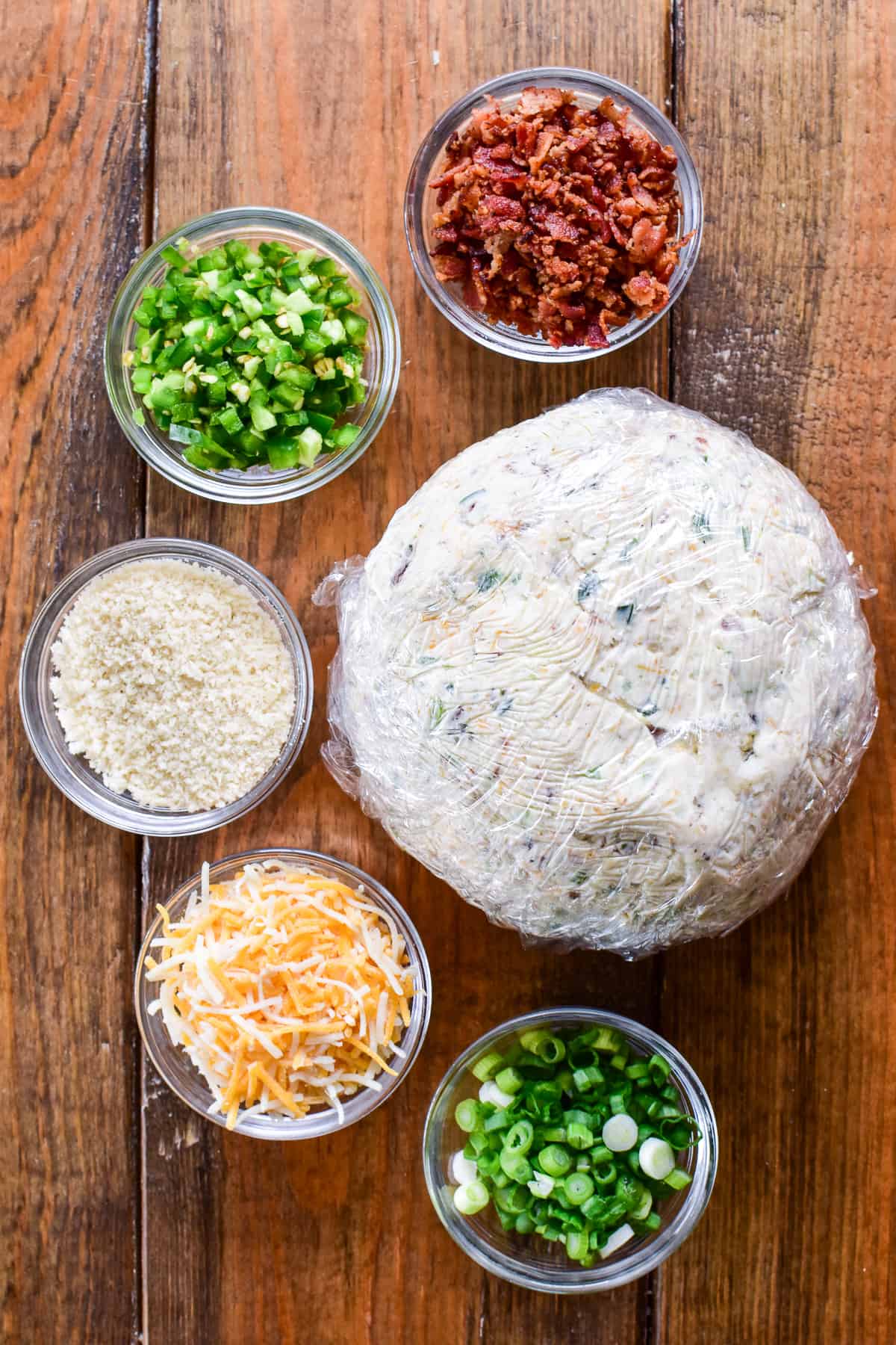 Plastic wrapped cheese ball with topping ingredients