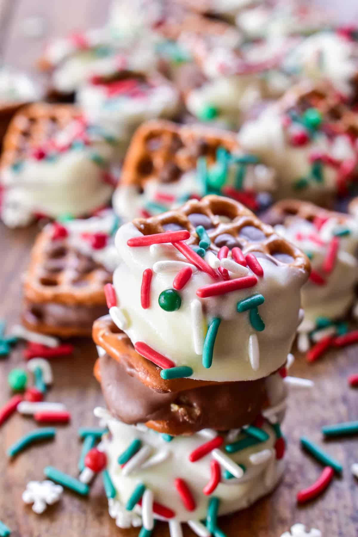 White chocolate dipped pretzel squares stuffed with peanut butter cups and decorated with red and green sprinkles