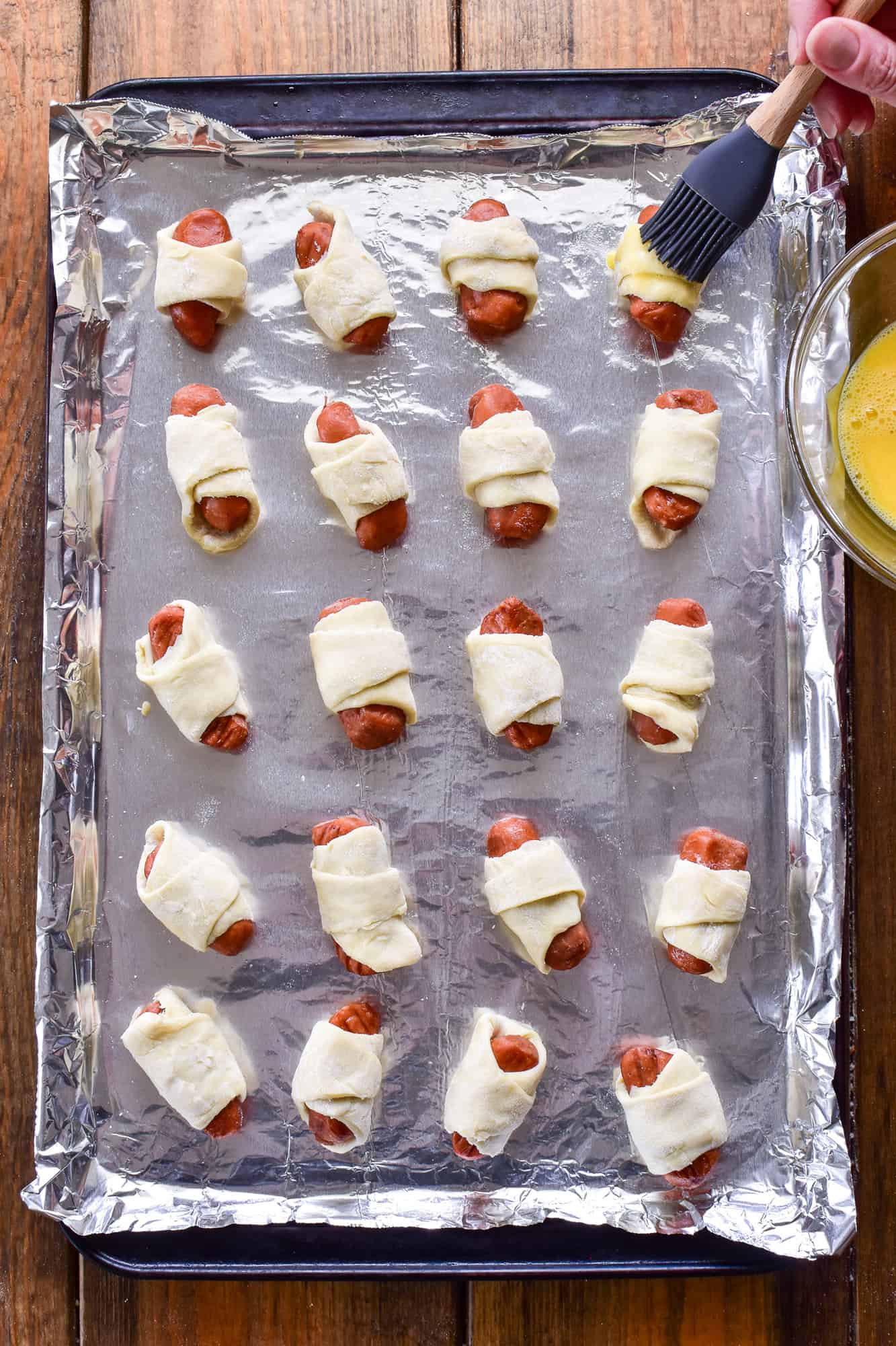 Unbaked Pigs in a Blanket on a baking sheet