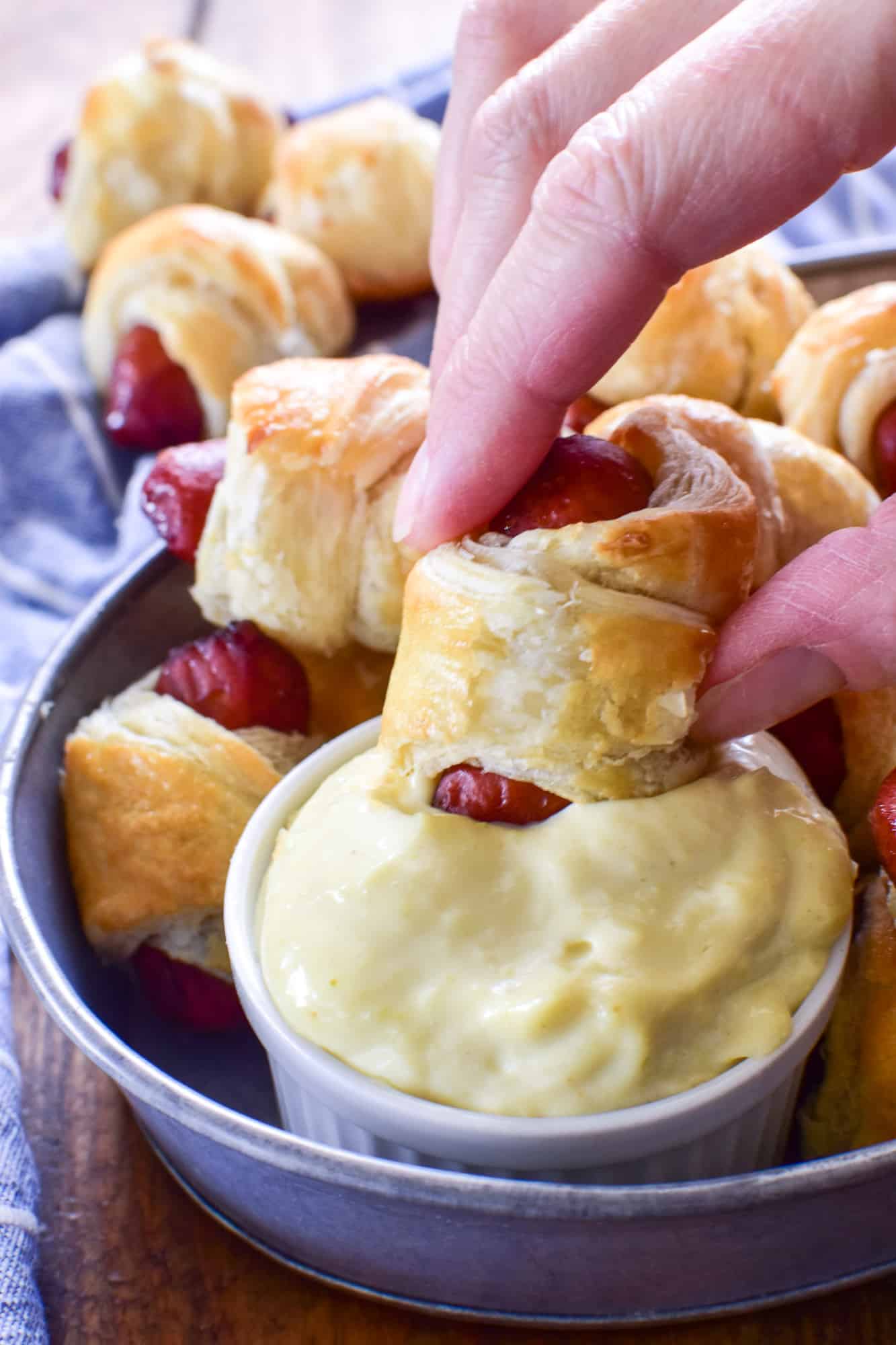 Pig in a Blanket being dipped into wasabi mayo