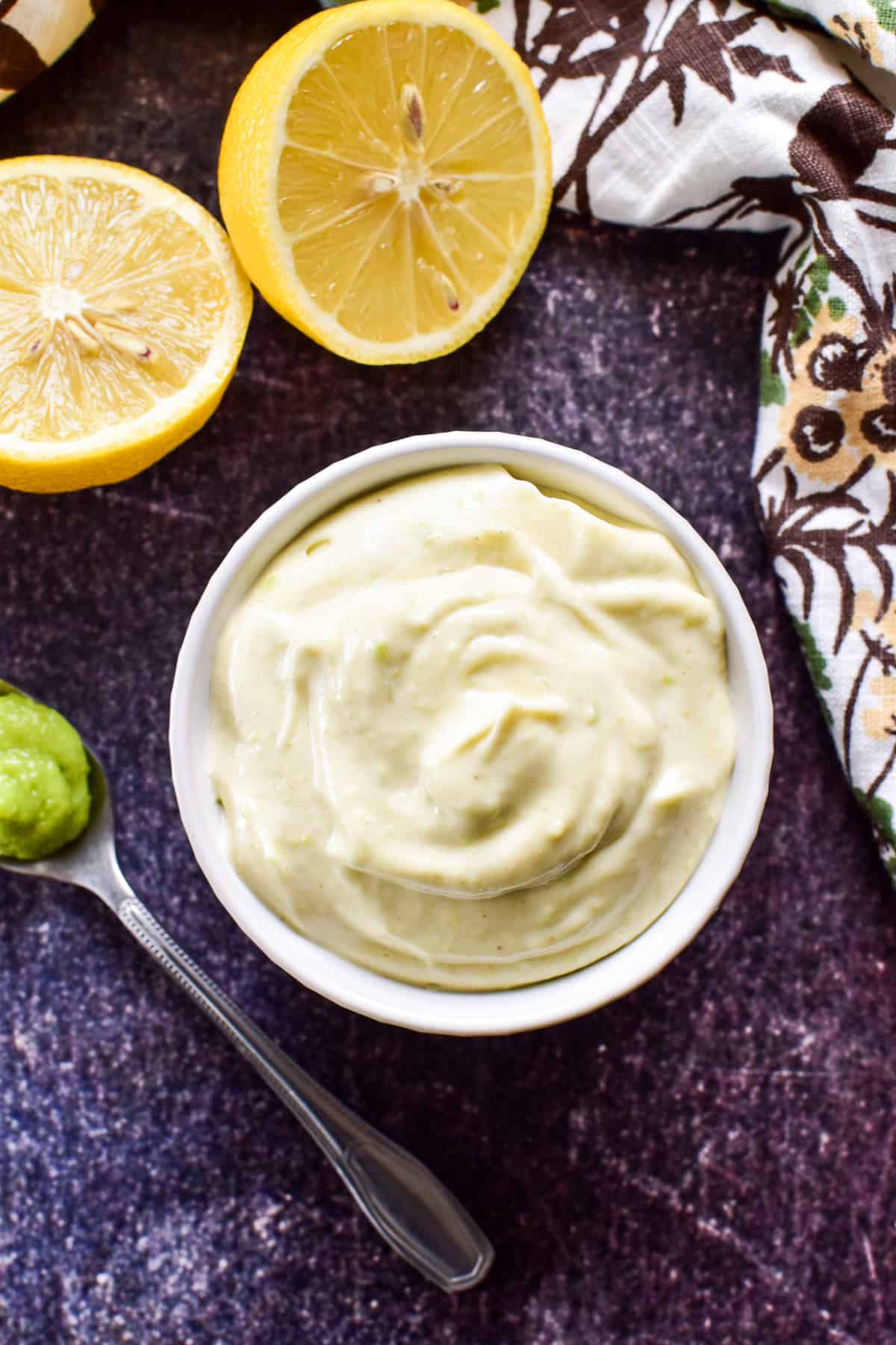 Overhead image of Wasabi Mayo in a white bowl with a spoonful of wasabi paste and a cut lemon