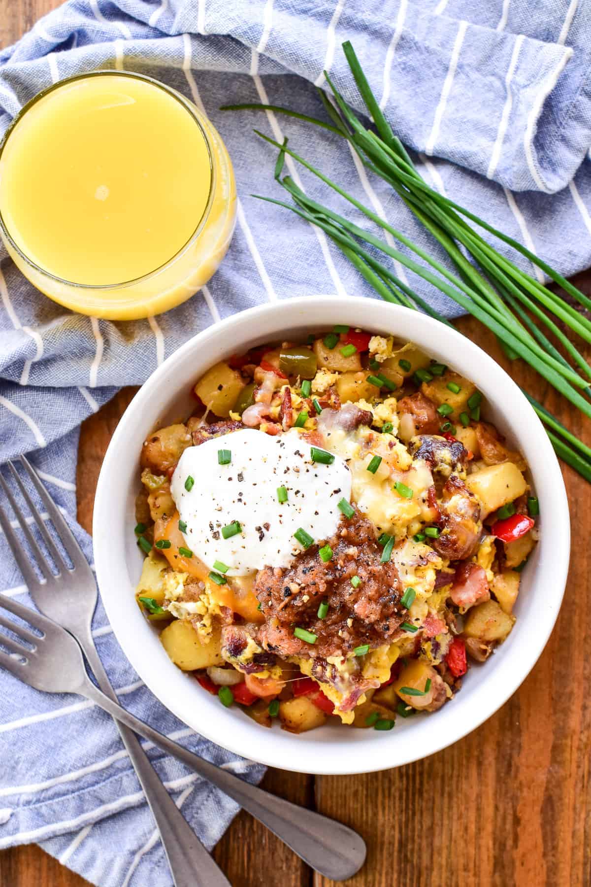 Overhead image of Breakfast Bowl with a blue and white striped towel, a mimosa, and 2 forks